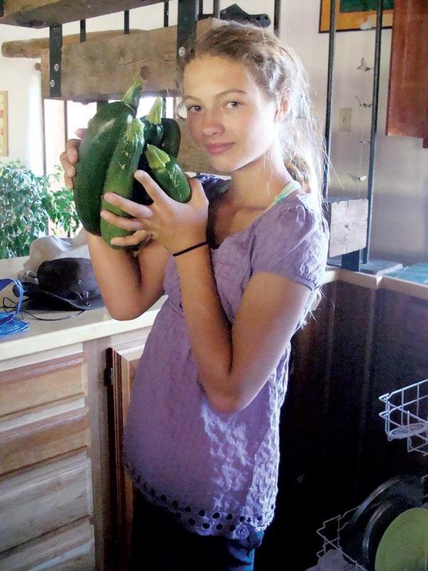 Treska with her harvest of zucchini and cucumbers.